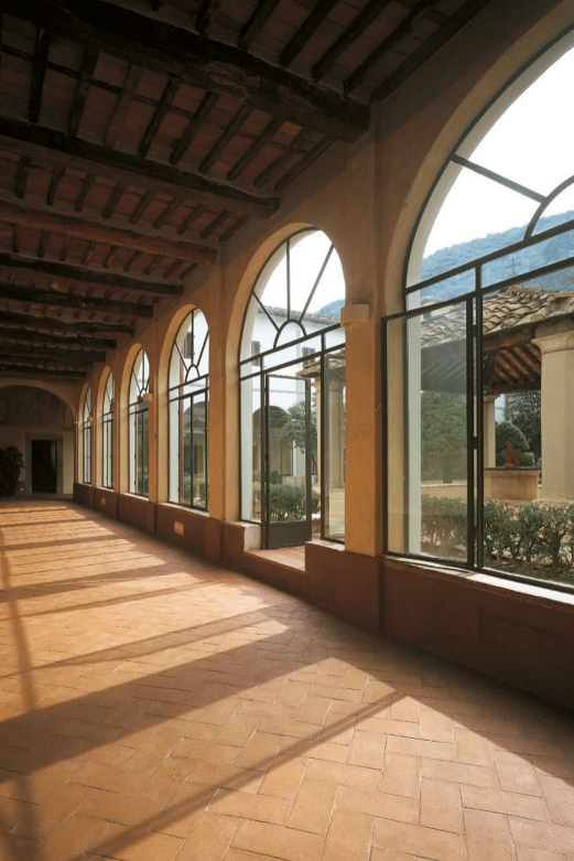 Hallway with beautiful arches and terracotta tile floor.